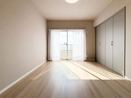 大きな開口部から陽光が差し込む、明るく開放的な洋室です。