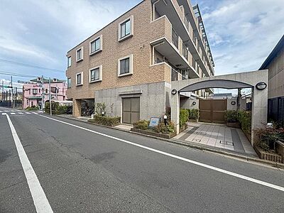 外観：落ち着いた色合いの外観が街並みに溶け込むマンション。広々とした道路に面し、お子様との散歩も安心。家族の毎日を優しく見守る住まいです。