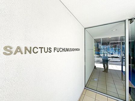 「SANCTUS FUCHUMUSASHINODAI」のロゴが輝く、洗練されたエントランス。AEDも完備され、ご家族の安心を支える共用空間です。