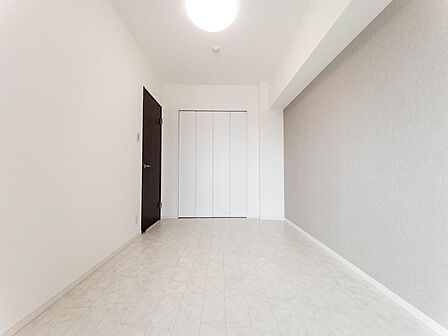 大きな窓から自然光が差し込む洋室です。ベッドやデスクも配置しやすい形状で、主寝室や書斎、子ども部屋など多目的に活用できます。明るさを確保しながら落ち着いて過ごせる居住空間です。