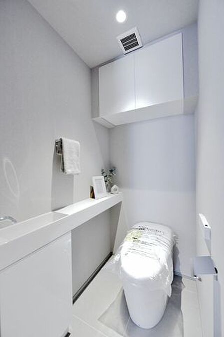 TOTO製ウォシュレット一体型のタンクレストイレ新規交換済みです。手洗いカウンターを設置していますので、家族やゲストがいつも清潔に使用できます。吊戸棚設置済みで、小物類の収納に便利です。