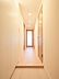 玄関：淡い木目と白い壁が調和した玄関です。ガラス扉がもたらす抜け感により、より広がりを感じられる空間に仕上がっています。