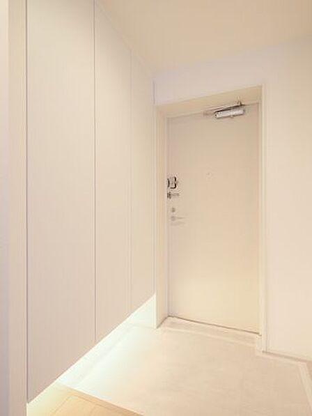 フットライトからのびる光が足元を優しく包み込む玄関です。人感センサー付きライトを設置したので、暗い時間帯のご帰宅や両手が塞がっているときも快適です。