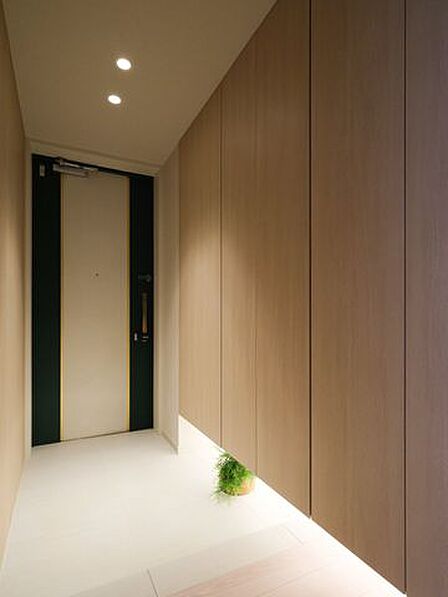 フットライトからのびる光が足元を優しく包み込む気品溢れる玄関です。玄関には頼もしい収納力をもつシューズボックスを備え付けました。