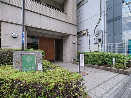石貼りのアプローチと植栽の緑が調和するエントランスです。木調の扉が温かみを添え、住まう方や訪れる方をやさしく迎えます。