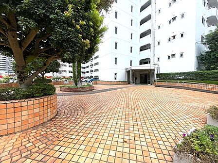 豊かな緑とタイル敷きの敷地が心地よいゆとりあるエントランスアプローチです