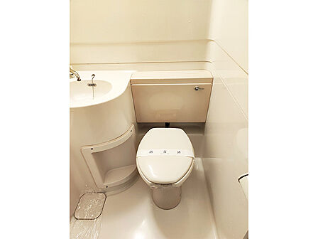 【トイレ】便器背面には、洗面用品や小物類を置けるスペースが設けられています。洗面台下部にも収納スペースが備わり、掃除用品などを収納いただけます。