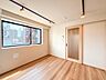 リビング/ダイニング：天井のライティングレールとスポットライトがスタイリッシュな空間を演出。大きな採光窓から自然光がしっかりと差し込み、温かみのある木目調フロアと調和します。
