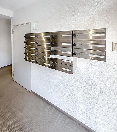 エントランス内にあるダイヤル式の集合ポスト。整頓された清潔感のある共用空間です。