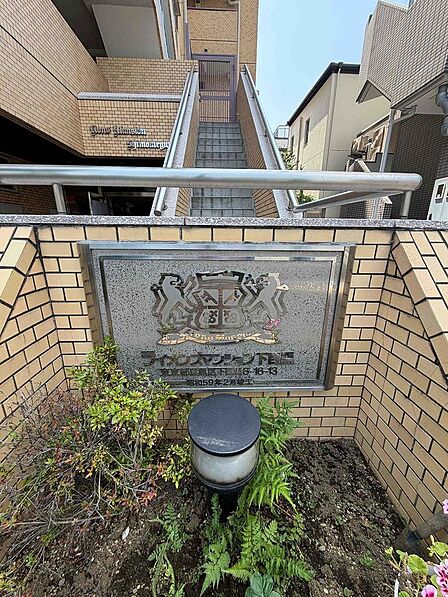 緑を配したシックで高級感のある館銘板。マンションの顔として品格を漂わせます。