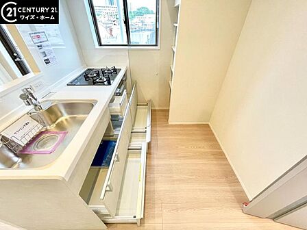 【キッチン】　効率的にお料理できる便利な3口コンロをはじめとしフライパンなど大きな料理道具をきれいに収納できる機能的な大型収納スペースが備わった快適なキッチンスペース