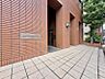 エントランス：【エントランス】重厚感のあるタイル壁に美しく映える、モダンなデザインのマンションサイン。