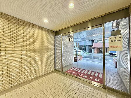 【エントランス】外の喧騒を忘れさせる、落ち着いたタイル貼りのモダンな空間。