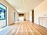 洋室：家族が集う一戸建ての広々としたリビング。大きな窓から明るい光が差し込み、開放感にあふれた空間です。家具の配置も自由自在で、家族団らんの時間を心地よく演出。家族の笑顔と会話が自然と弾む住まいの中心です。
