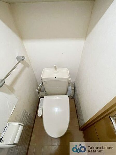 ウォシュレット機能付きのトイレ。ペーパーホルダーやタオル掛けは標準装備しています。