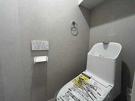 ~トイレ~ 上部に吊戸棚が設置された温水洗浄機能付きのトイレです。