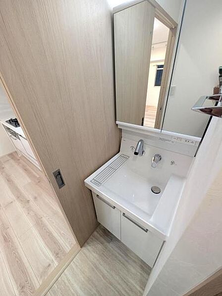 新規設置の洗面化粧台。大きな鏡と綺麗な水受け、朝の身支度がはかどります