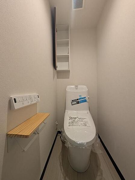 洗浄便座のトイレはスタイリッシュなデザイン、背面の棚に収納もできます