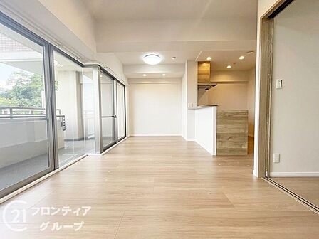 大きな窓から明るい陽光が差し込むリビングは開放感に満ち溢れています。コンシェルジュサービスなどの充実したサポートが日常の快適さを支え、上質な家具が映える洗練された空間が広がります