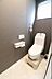 トイレ：落ち着いた色合いの壁紙と明るい床が調和したトイレ空間。窓から光が差し込み、清潔感のある空間です。