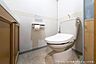 トイレ：清潔感のあるトイレ空間です。温水洗浄便座と収納棚が備わっており、快適にお使いいただけます。