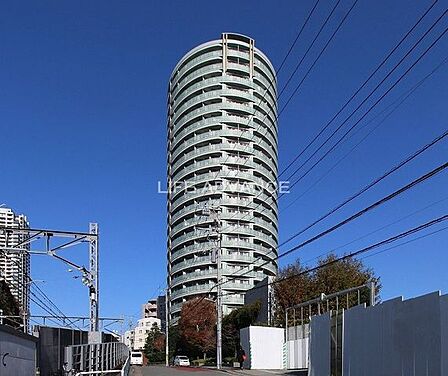 丸みを帯びた曲線のフォルムが特徴的な高層タワーマンションで、各階のバルコニーにはガラスパネルの手すりが連続して配置されており、淡いグリーン基調の爽やかな色彩で構成された外観デザインとなっております。