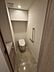 トイレ：タンクレスタイプのトイレには手洗いカウンターや壁面の手すりが備え付けられているほか、上部には扉付きの吊戸棚が設置されており、トイレットペーパーなどの備品類をスッキリと収納できます。
