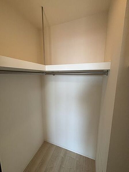 固定棚とハンガーパイプがL字型に備え付けられた収納スペースで、衣類を吊るして保管できるほか、棚の上部にはバッグや季節物のアイテムなどを整理して置くことが可能な構造となっています。