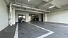 駐車場：建物内に設置された屋根付きの駐車場スペースには、明確に区分された白線が引かれており、天井部には照明器具が取り付けられ、奥には出入口となる扉や駐車スペースが整備されています。