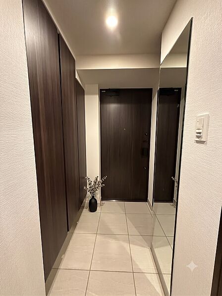 落ち着いた木目調の大型シューズボックスと姿見を完備した、気品漂う玄関スペース。※家具や装飾はCG画像となり販売対象には含まれません。
