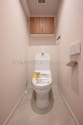 温水洗浄便座付きトイレには吊戸棚を設置。トイレットペーパーなど買い置きもしやすそうです。