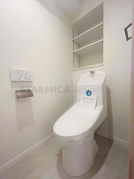 白を基調にした清潔感のあるトイレには、便利な棚板を設置