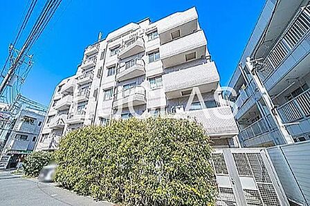 青空が映える外観のマンション。前面の植栽が、日々の暮らしに潤いをもたらします。