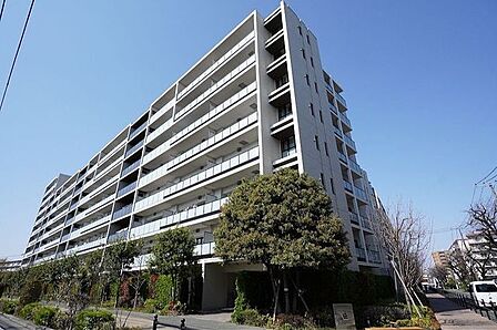 重厚感ある外壁と鮮やかな緑が魅力的な外観です。植栽の葉が季節の移り変わりを感じさせてくれます。