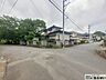 外観：角地に位置し、開放感と優れた通風・採光性を誇る戸建ての外観です。緑豊かな周辺環境と調和する落ち着いた佇まいで、敷地内にはゆとりある駐車スペースや庭木も備えた魅力的な住まいです。