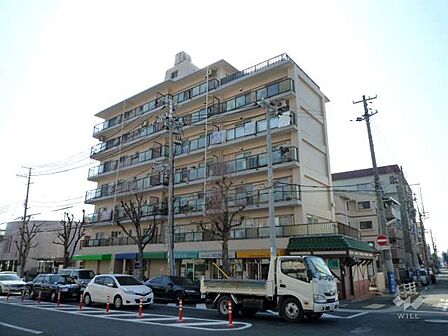 甲南深江ハイムの外観（北東側から）です。敷地は北東角地で、1階には店舗部分があります。