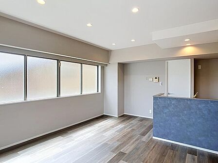 大きな窓から明るい光が差し込むリビング。落ち着いた木目調の床材が魅力です。