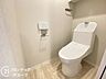 トイレ：快適な温水洗浄便座に新規交換されたトイレです。衛生面にも配慮された清潔な空間で、上部にはペーパーや掃除用品の保管に便利な収納棚も設置されています。