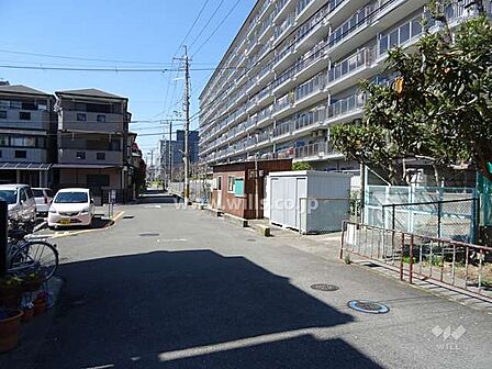 ローレルハイツ茨木1号棟の南側前面道路。周辺はマンションや一戸建て、店舗等が混在する住宅地です。お気軽にお問い合わせください！