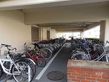 駐輪場。周辺は平坦地のため、自転車での移動がスムーズ！屋内のため、自転車が雨晒しになりません。駐輪場の最新の空き状況につきましてはお問い合わせください！