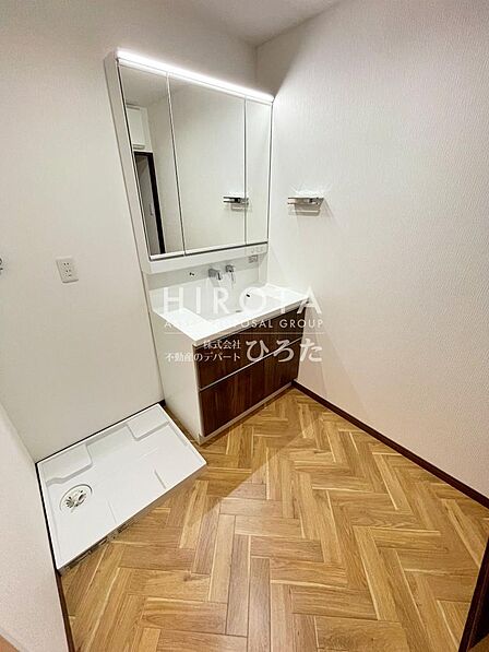 ワイド鏡を使用した洗面台を使用。蛇口が壁面に設置されたハイバックタイプなので清掃が楽です。