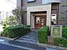 エントランス：壁を花崗岩貼りで仕上げたピロティとエントランスの木製扉。まるでホテルのエントランスを思わせるような、味わい深く、重厚な雰囲気を感じられます。