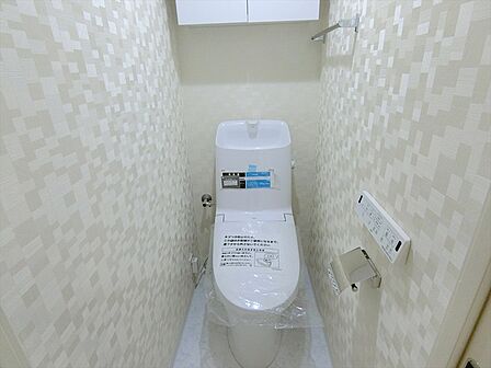 いつも快適に利用できるシャワー機能付きトイレを新規設置。上部には収納棚もございます。