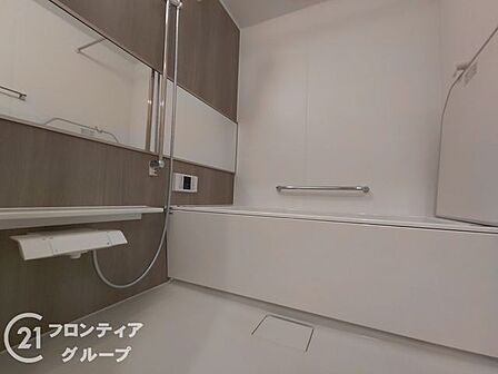 木目調のパネルが落ち着きを演出する浴室は、一日の疲れを優雅に解きほぐす至福の空間です。手すりや棚が配置された使い勝手の良い設計が、毎日のバスタイムに安心とゆとりをもたらします
