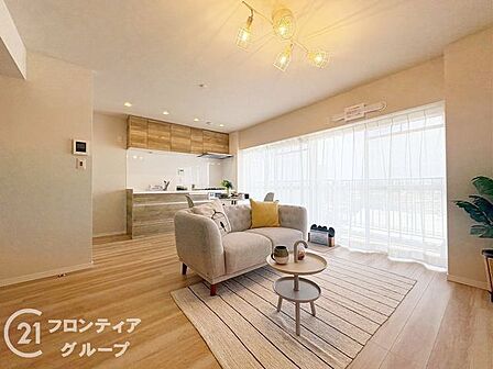 大きな窓から柔らかな光が差し込む開放感たっぷりのリビングルームです。上質なインテリアが映えるフラットな空間設計により、家族全員が自然と集まりたくなるような暖かみのある住まいを実現します