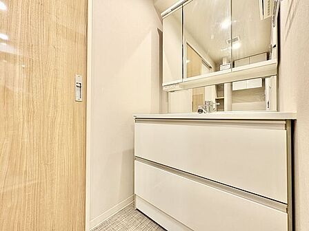 三面鏡の付いた洗面化粧台は、鏡面裏側にも機能的な収納を配置。スキンケア用品などが収納できます。