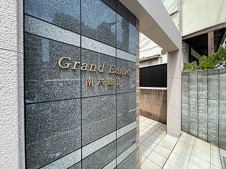 上品さ溢れるマンション名プレート。安らぎと癒やしの住まいへ温かく迎えてくれます。