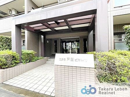 エントランス外部は落ち着いた外観デザイン。エントランスのサイドには植栽を配し、緑の潤いにあふれたアプローチを実現。
