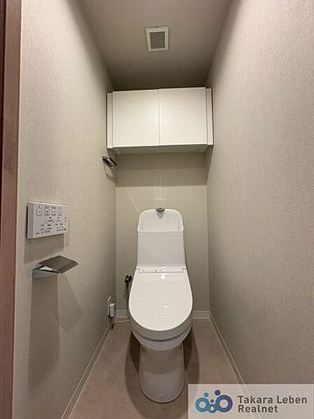 ウォシュレット機能付きのトイレは壁掛けリモコンの上位グレードを採用。便座がスッキリした印象となり、限られた空間を広く見せる効果があります。