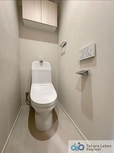ウォシュレット機能付きのトイレは壁掛けリモコンの上位グレードを採用。便座がスッキリした印象となり、限られた空間を広く見せる効果があります。
